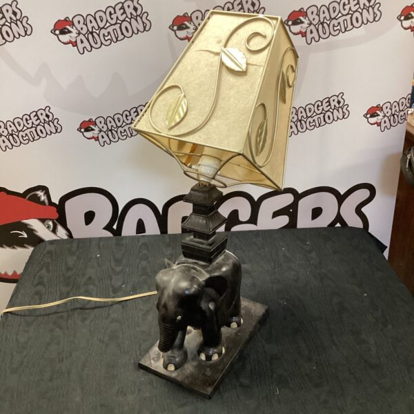 Vintage ceramic elephant table lamp with neutral shade.