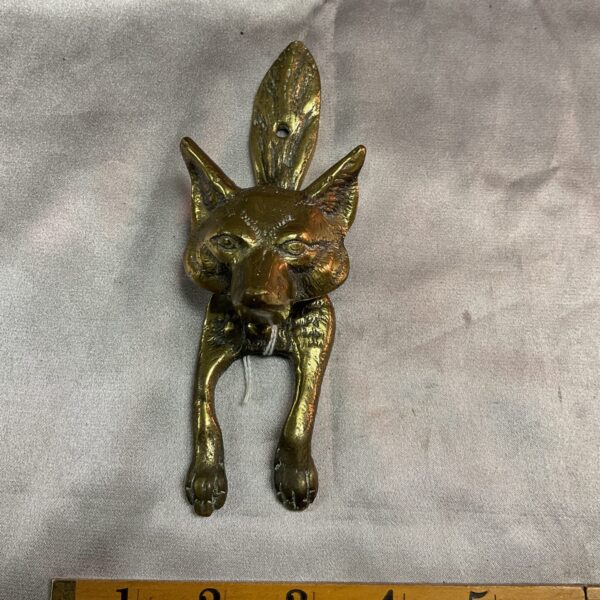 Antique brass fox door knocker with detailed features.
