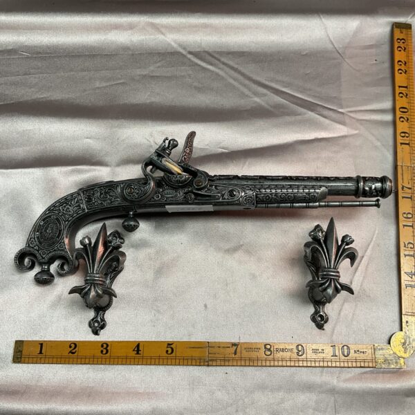 Detailed reproduction flintlock pistol mounted on a wall.