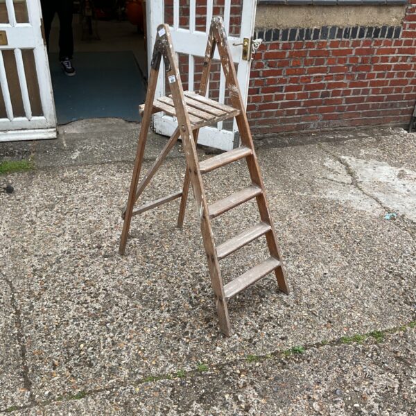 Vintage wooden folding step ladder with three steps.
