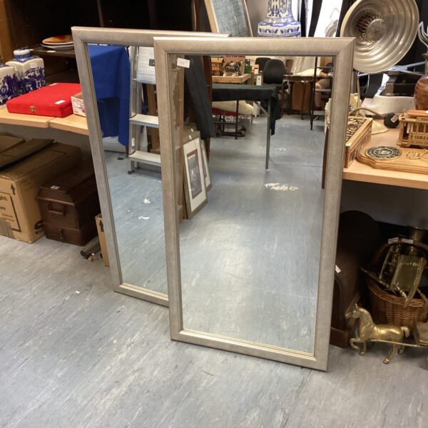 Vintage rectangular wall mirror in a hallway setting.