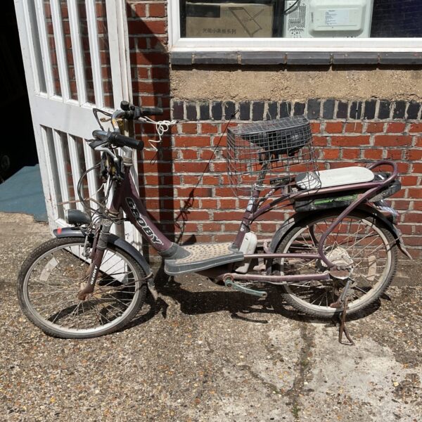 Front view of a vintage Geoby electric bike with a basket.