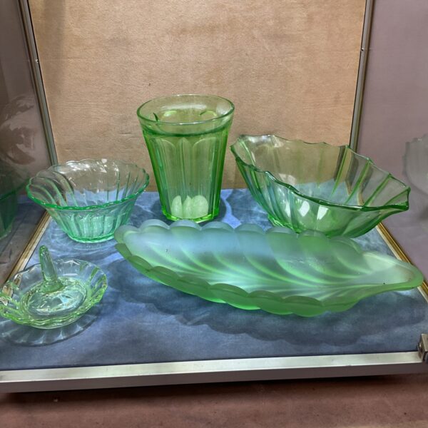 Vintage green uranium glass collection displayed on a surface.