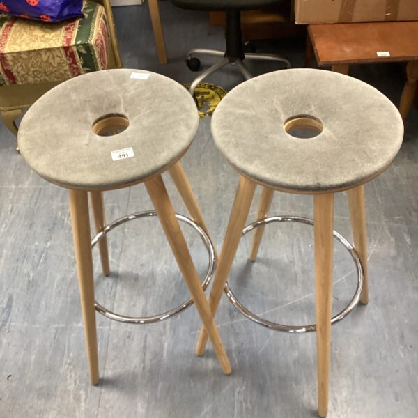 Two vintage donut stools with chrome legs and wooden seats.