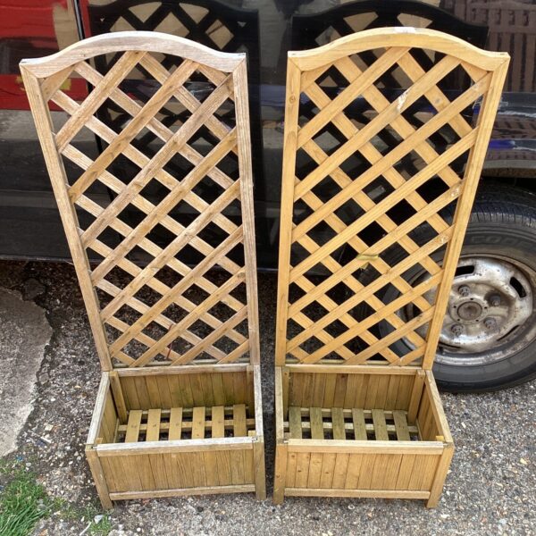 Pair of wooden garden planters with trellis supports for climbing plants.