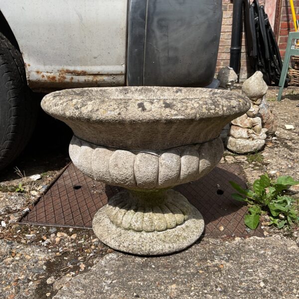Classic concrete pedestal urn in a garden setting.