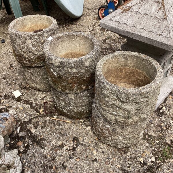 Six weathered stone garden planters for outdoor garden decor.