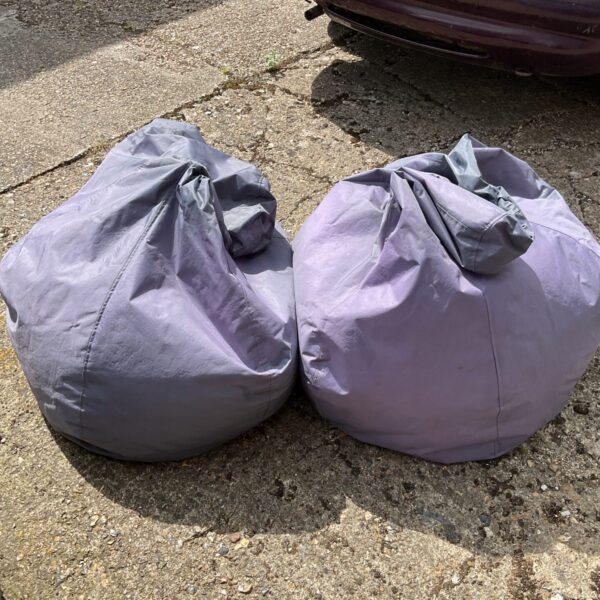 Pair of large outdoor bean bags in a garden setting.