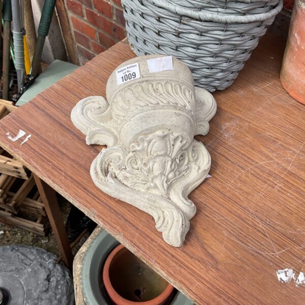 Vintage garden stone ornament with floral relief carving.