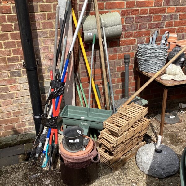 Mixed lot of garden tools and terracotta pots for outdoor use.