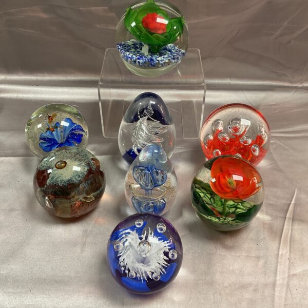 Assorted glass paperweights displayed as a collectible lot.
