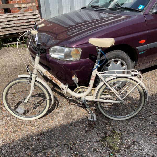 Vintage Wayfarer folding bicycle in a garden setting.