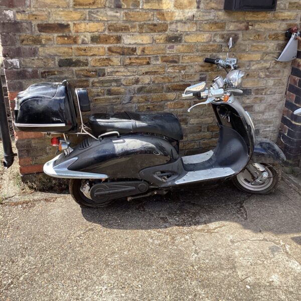 Side view of a Jaunce Chinese electric scooter in untested condition.