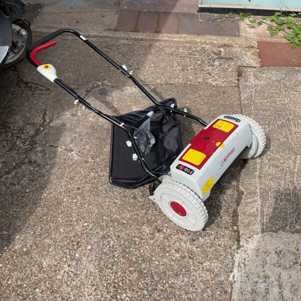 Vintage Eckman 24v cylinder mower in a garden setting.