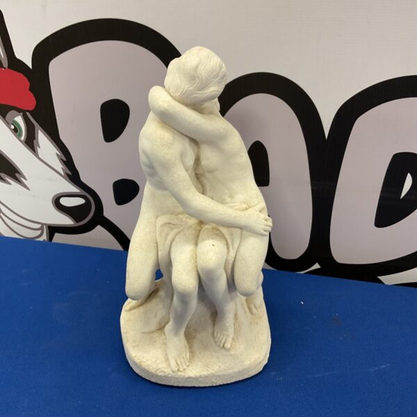Vintage porcelain sculpture of lovers embracing romantically.