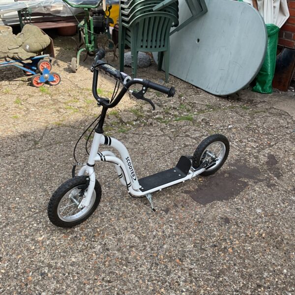 A used kids kick scooter in an outdoor setting.