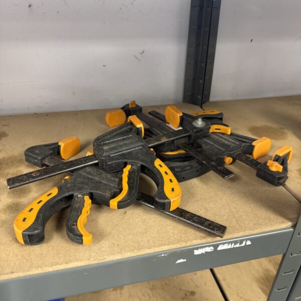 Set of four 6 inch woodworking bar clamps for securing wood projects.
