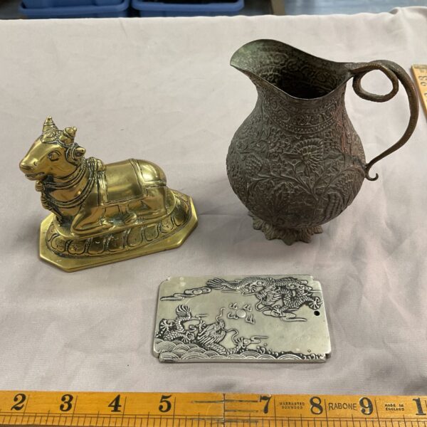 Mughal style jug, dragon plaque, and brass cow in a lot.