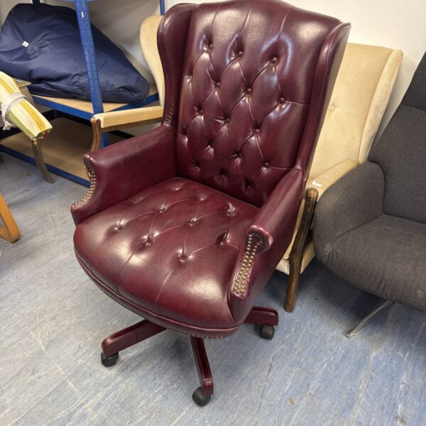 Burgundy faux leather chesterfield office chair with studded arms.