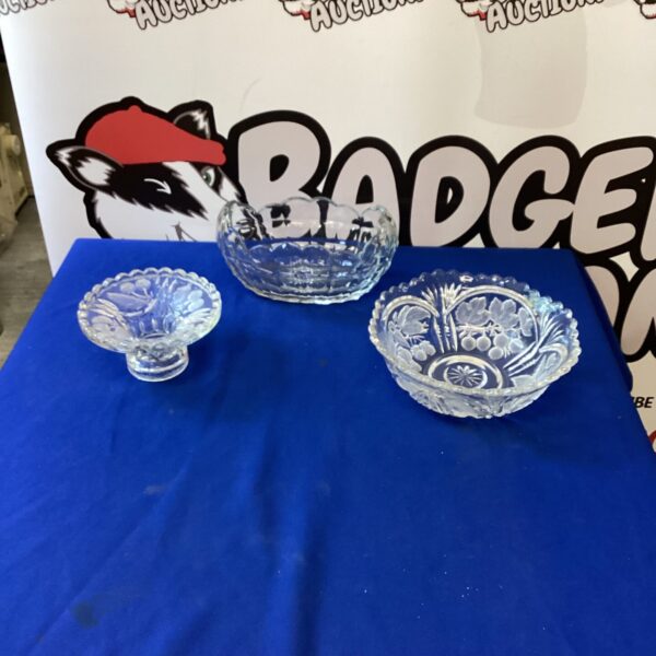 Three vintage cut glass and crystal bowls on display.