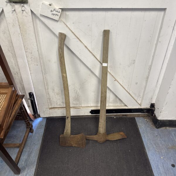 Vintage mattock axe with wooden handle and metal head.