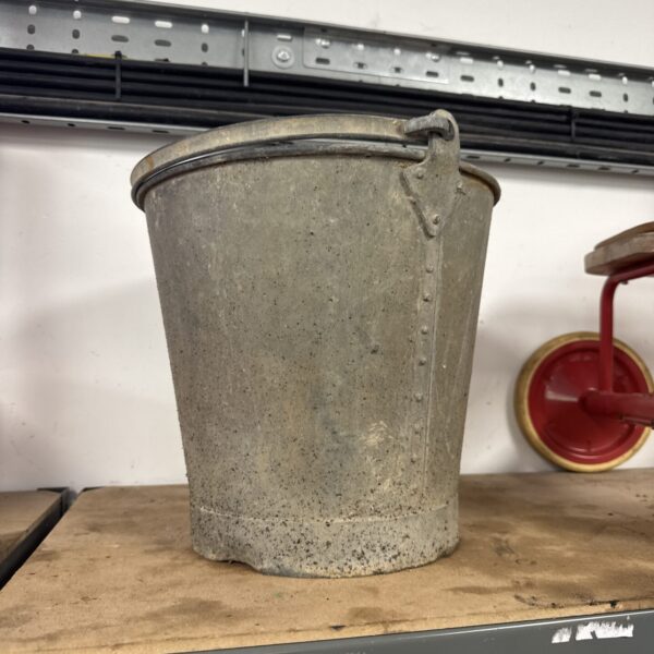 Weathered vintage galvanised bucket with handle, rustic farm tool.