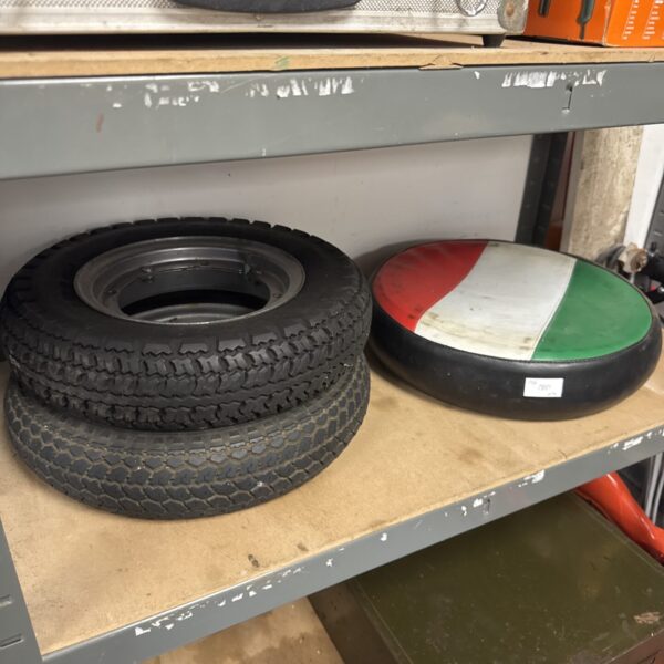 Vintage Vespa scooter wheels with Italian flag cover.