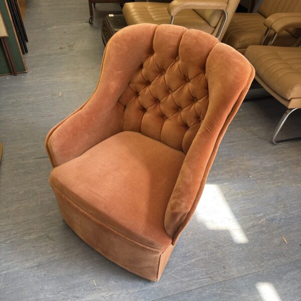 Vintage velour armchair with button back detailing.