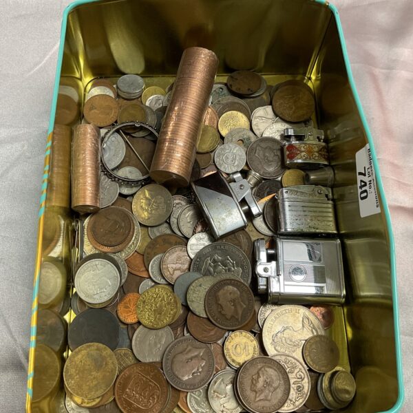 Assorted coins and vintage lighters in a mixed lot collection.