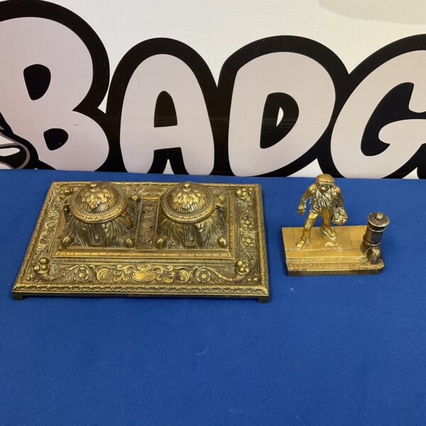 Vintage Art Nouveau inkwell with brass milkman figurine on display.