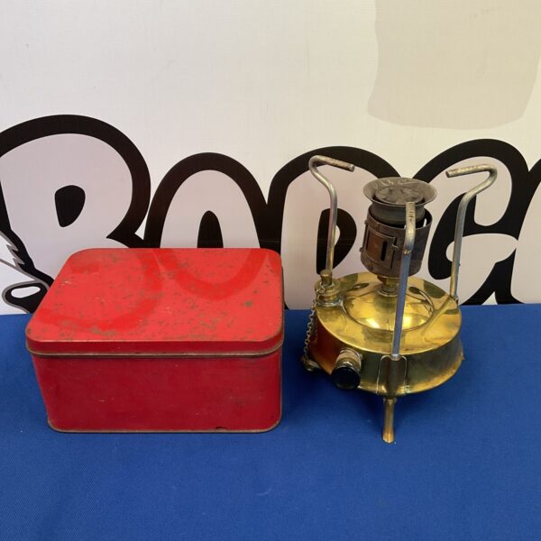 Vintage brass paraffin stove in original tin for camping.