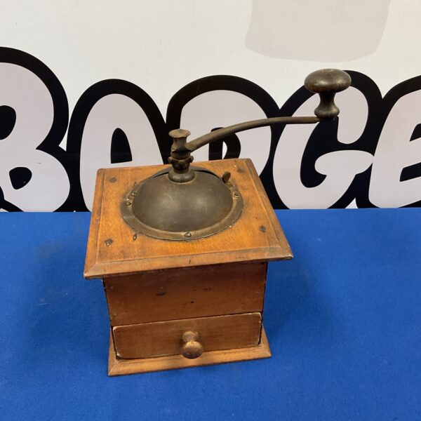 Front view of a vintage wooden hand-crank coffee mill.