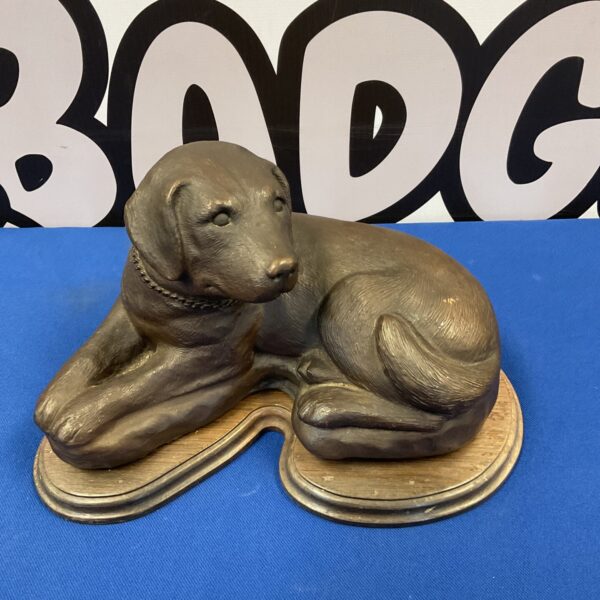 Detailed bronze Labrador puppy sculpture on wooden base.