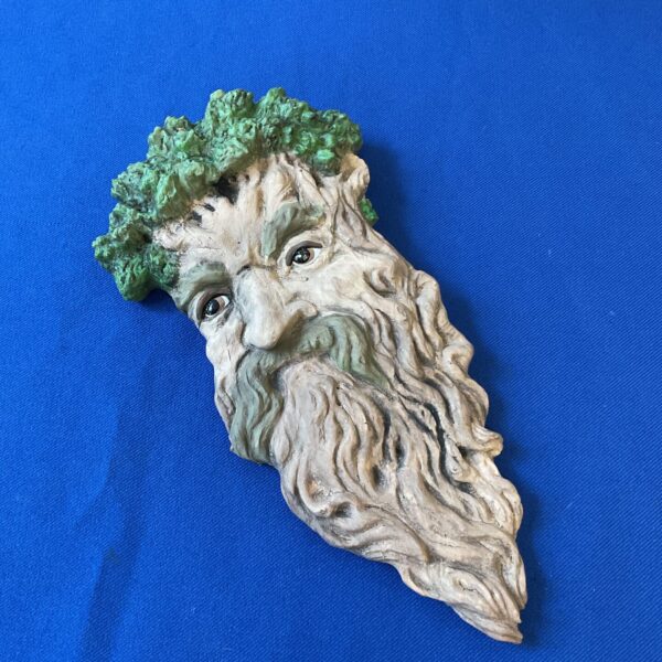Detailed stone Green Man wall plaque with foliage design.