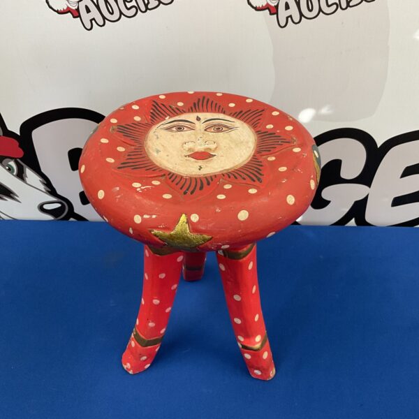 Painted folk art stool with a whimsical face design.