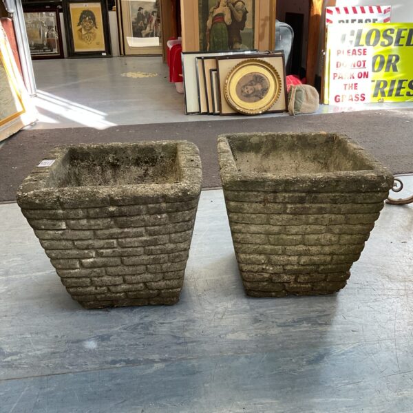 Pair of rustic concrete brick planters for garden display.
