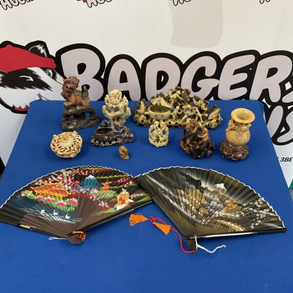 Chinese soapstone carvings and hand painted fans displayed together.