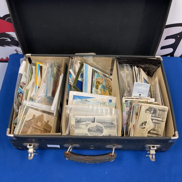 Vintage suitcase filled with a diverse postcard collection.