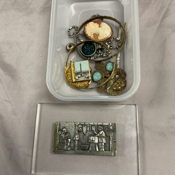 Vintage costume jewellery tray with brooches and a plaque.