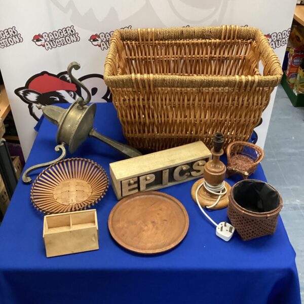 Wicker basket filled with vintage wooden items and brass lamp.