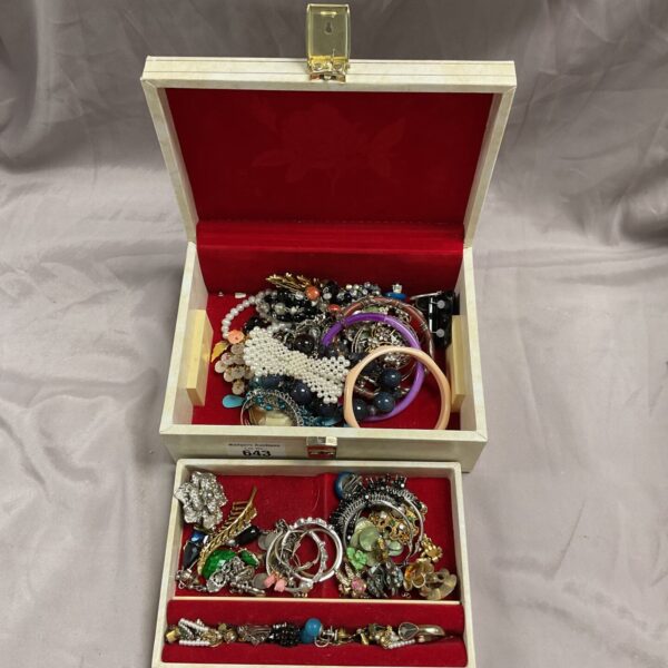 Vintage jewellery box filled with assorted costume jewellery pieces.