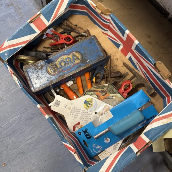 Assorted hand tools and garden implements in a shed clearance lot.