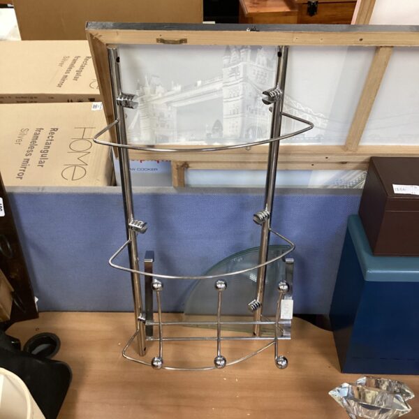 Vintage chrome coat rack with glass shelves for hallway storage.