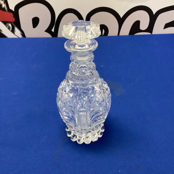 Antique cut glass shampoo decanter with intricate detailing.