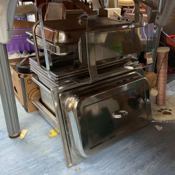 Stack of stainless steel food trays for catering and kitchen use.