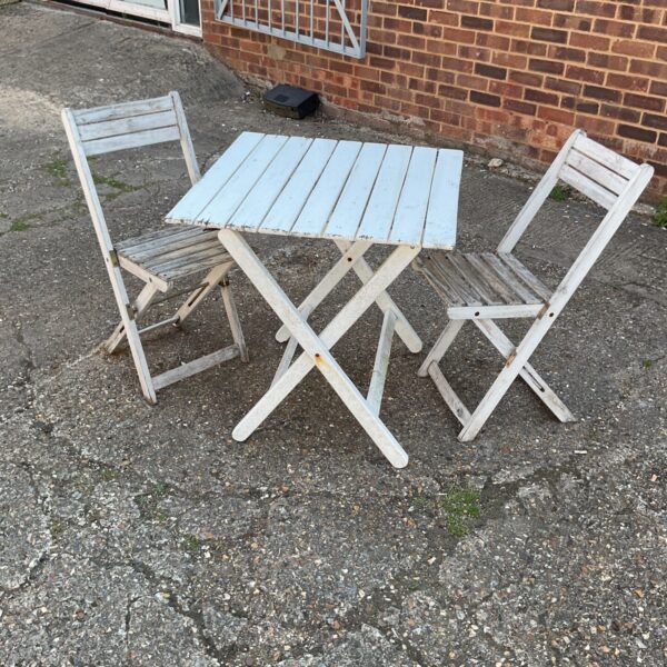 White wooden garden furniture set with folding table and chairs.