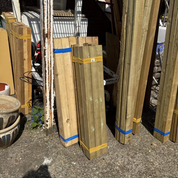 Three bundles of softwood timber secured with plastic strapping outdoors.