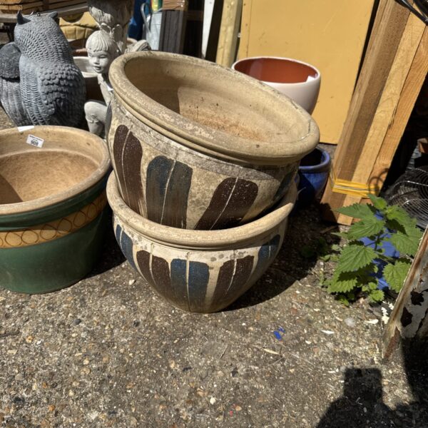 Stacked terracotta garden pots in a garden setting.