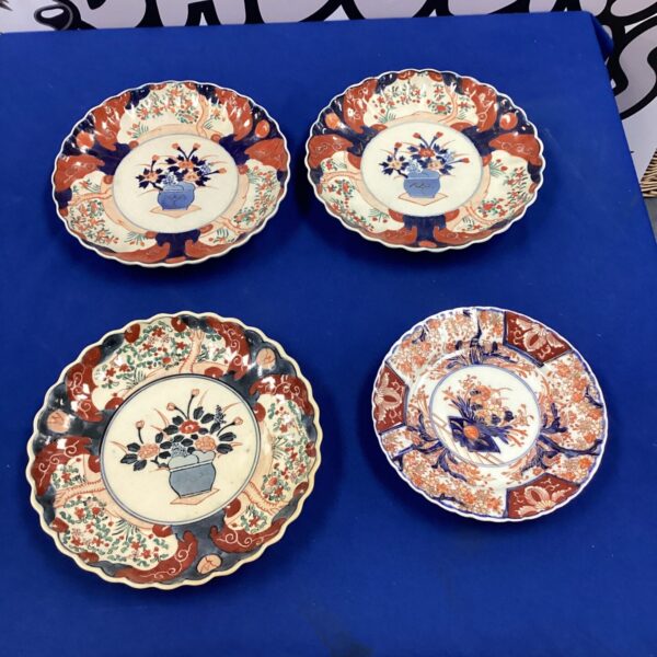 Set of four vintage Japanese Imari plates with floral designs.