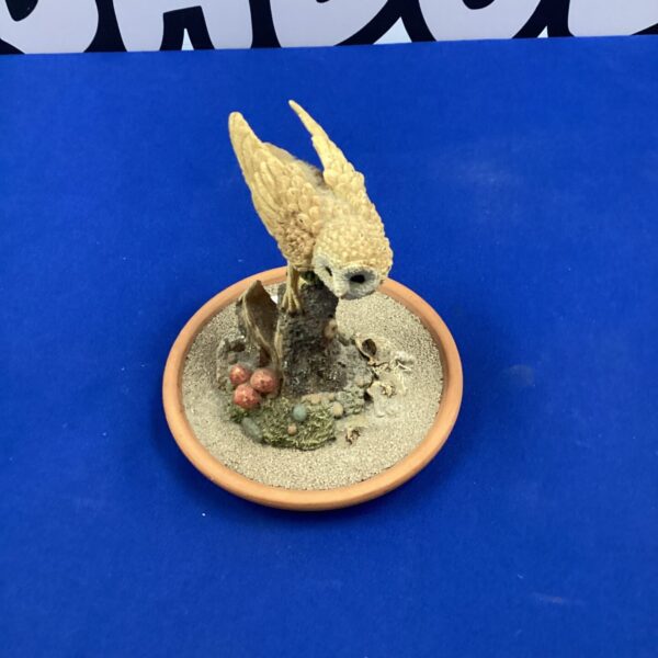 Detailed resin tawny owl ornament on terracotta base.